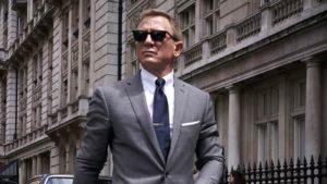 Image of Daniel Craig playing James Bond. He is wearing a grey suit and sunglasses