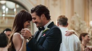 A young, well-dressed couple dancing in a ballroom.