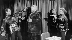 Retro-futuristic spaceman confronted by a tall, bald monster while two cosmonauts with ray guns watch in fear.