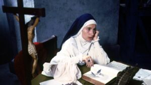 A nun stairs in to the distance while reading the Bible