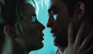 A close up as Jennifer Lawrence holds Robert Pattinson's face, as if they are about to kiss.