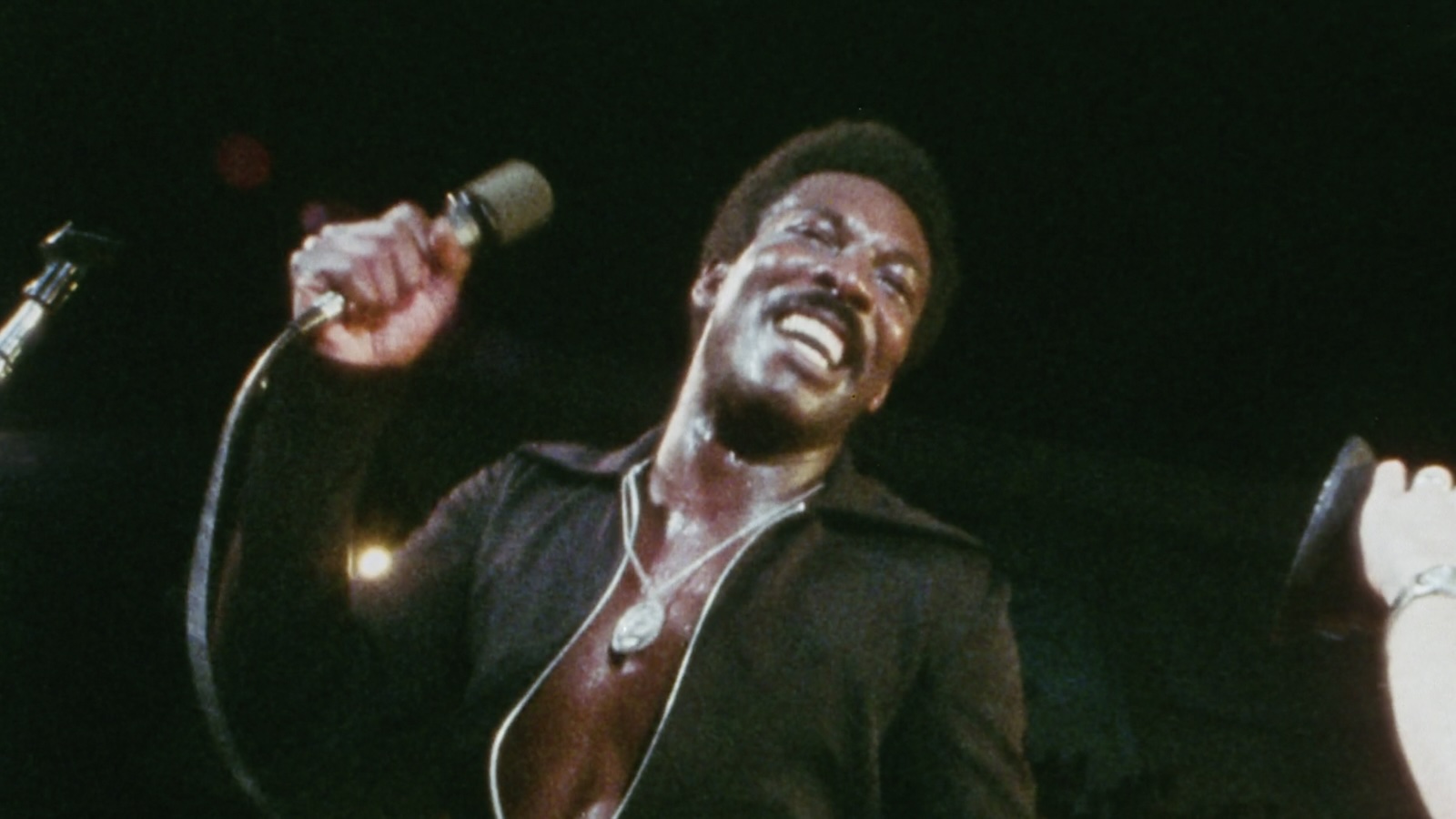 Black and white image of a man in a suit overlaid with textured psychedelic imagery.